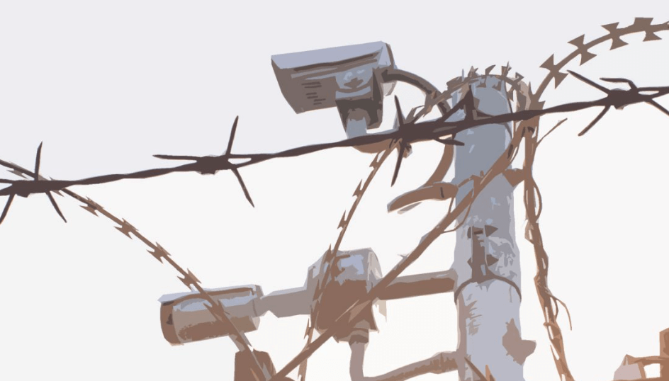 Outdoor surveillance cameras shown on top of a poll, towering over barbed wire fence.