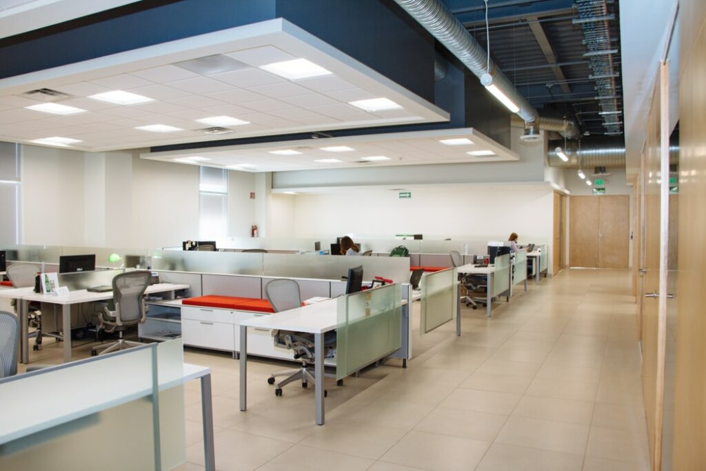 An empty set of cubicles in a modern office space.