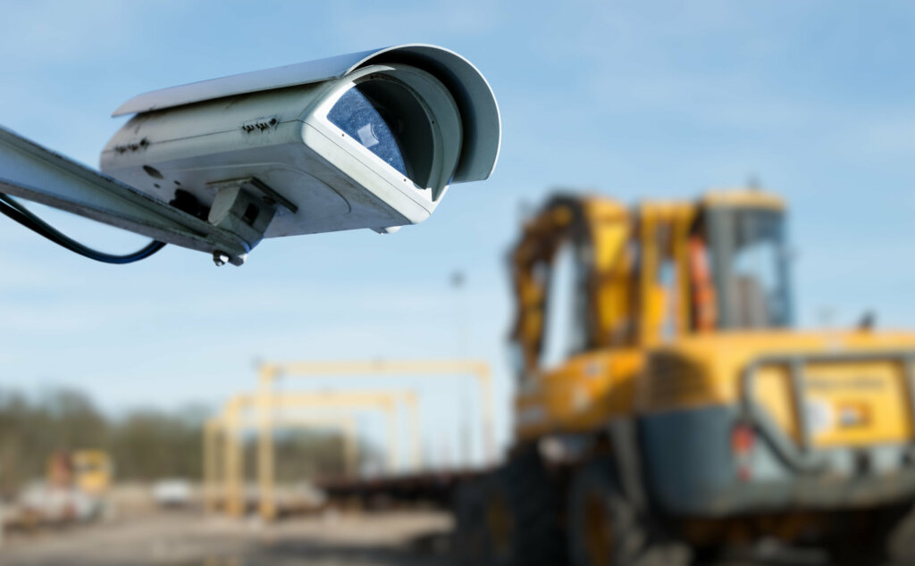 security CCTV camera or surveillance system with industrial site on blurry background